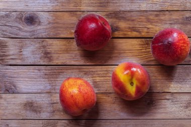 Yatay fotoğraf sulu şeftalileri gösteriyor. Yıkandılar ve sudan ıslandılar. Şeftaliler ahşap bir arka planda yatıyor.