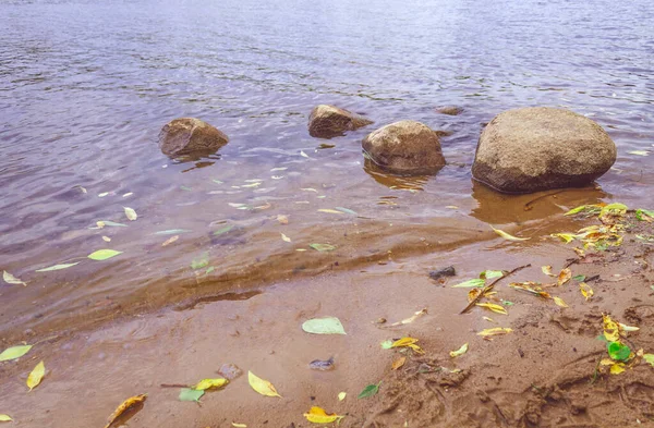 Τέσσερις πέτρες διαφορετικού μεγέθους κείτονται στο νερό η μία μετά την άλλη. — Φωτογραφία Αρχείου