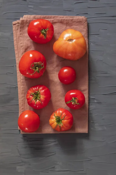 Eight fresh tomatoes lie on a brown towel Stock Photo