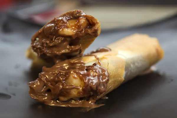 Fried Nutella muz Spring Rolls beyaz tabak içinde. Harumaki bir tabak içinde.
