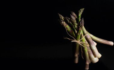 Siyah arka planda bir sürü yeşil kuşkonmaz.