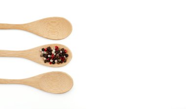 Beyaz arka planda biberli ahşap kaşık.