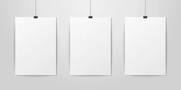 Три векторных реалистичных белых пустых вертикальных плакатов формата А4, висящих на веревке с нарезкой на белой стене. Пустой шаблон дизайна плакатов для графики, макет — стоковый вектор