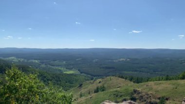 Yeşil ormanlarla kaplı dağların panoramik manzarası. Yaz manzarası. Sabah ışığı, sis. Dağ manzarası.