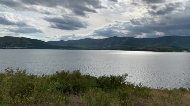 Summer landscape. Mountain lake. Beautiful blurred background of colourful flower. A large green field with trees and mountains in the background. A body of water with a mountain in the background — Stock Video