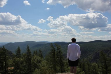 Dağın tepesindeki mutlu gezgin. Seyahat macera yaşam tarzı başarı kavramı aktif seyahatler