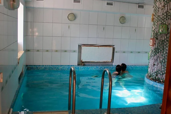 Человек в бассейне с голубой водой — стоковое фото