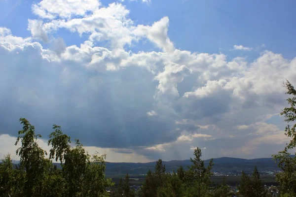En grupp moln på himlen ovanför en bergskedja — Stockfoto
