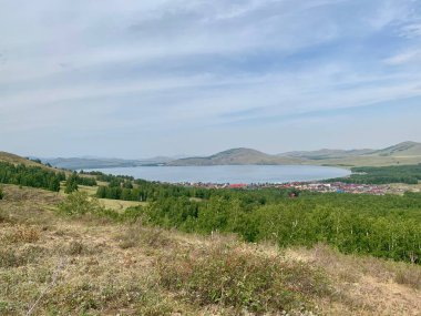 Yeşil orman vadisine güzel manzara ve güneşli bir günde büyük dağlar. Güneş ışığı altındaki muazzam genişliklerin muhteşem manzarası. Yeşil orman dağlarıyla muhteşem canlı bir manzara..