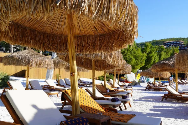 Beyaz kumsalda güneşli yataklar ve bambu şemsiyeli. Türkiye 'de güzel tropikal plaj