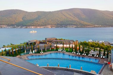 Bodrum, Türkiye - Ağustos 2020: Hotel Beach Lujo. Cennet 'te tatil. Güzel tropikal plaj afişi. Beyaz kum turizmi geniş panorama arka plan konsepti. İnanılmaz sahil manzaraları, yatlar.