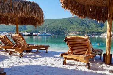 Bodrum, Türkiye - Ağustos 2020: Hotel Beach Lujo. Güzel tropikal plaj afişi. Beyaz kum turizmi geniş panorama arka plan konsepti. İnanılmaz sahil manzarası, yatlar, lüks turizm.