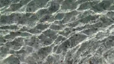 4K Rough derin turkuaz ve mavi Ege denizi. Güneş arka planında yansıyan berrak mavi su. Kristal deniz suyu.