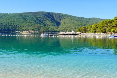 Bodrum, Türkiye - Ağustos 2020: Hotel Beach Lujo. Cennet 'te tatil. Güzel tropikal plaj afişi. Beyaz kum turizmi geniş panorama arka plan konsepti. İnanılmaz sahil manzaraları, yatlar.