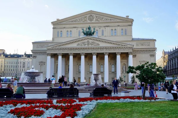 Moskva, Rusko - srpen 2020: Krásný výhled na divadlo Bolshoi s turisty v centru Moskvy, hlavní atrakce Ruska, Letní krajina s kvetoucími záhony — Stock fotografie
