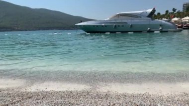 4K Güzel panoramik cennet manzaralı plaj beyaz kumlu, yatlı, göl kıyısında Ege Denizi 'nin zümrüt suyuyla kaplı evler, lüks turizm kavramı.