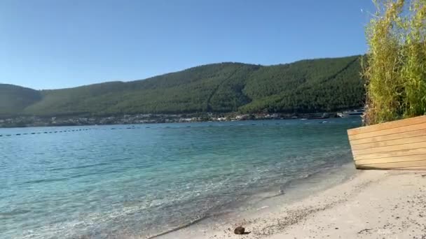 4K Indah panorama surga pemandangan pantai dengan pasir putih, kapal pesiar, rumah-rumah di atas air di laguna dengan air zamrud Laut Aegea, Luxury konsepsi pariwisata — Stok Video