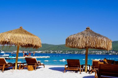 Bodrum, Türkiye - Ağustos 2020: Hotel Beach Lujo. Güzel tropikal plaj afişi. Beyaz kum turizmi geniş panorama arka plan konsepti. İnanılmaz sahil manzarası, yatlar, lüks turizm.