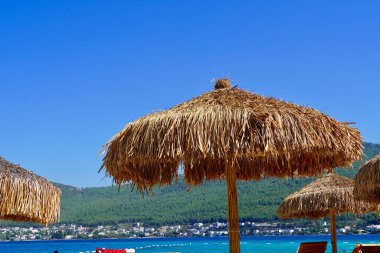 Bodrum, Türkiye - Ağustos 2020: Hotel Beach Lujo. Cennet 'te tatil. Güzel tropikal plaj afişi. Beyaz kum turizmi geniş panorama arka plan konsepti. İnanılmaz sahil manzaraları, yatlar.