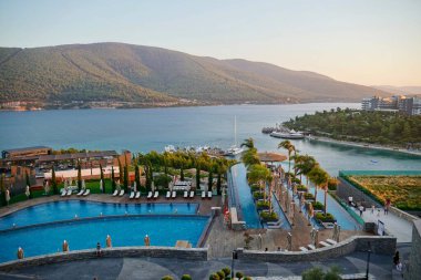 Bodrum, Türkiye - Ağustos 2020: Hotel Beach Lujo. Cennet 'te tatil. Güzel tropikal plaj afişi. Beyaz kum turizmi geniş panorama arka plan konsepti. İnanılmaz sahil manzaraları, yatlar.