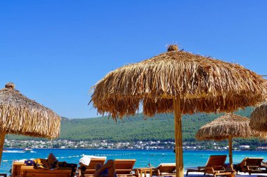 Bodrum, Türkiye - Ağustos 2020: Hotel Beach Lujo. Güzel tropikal plaj afişi. Beyaz kum turizmi geniş panorama arka plan konsepti. İnanılmaz sahil manzarası, yatlar, lüks turizm.