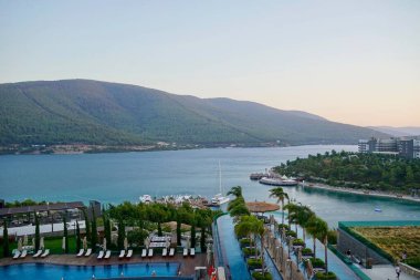 Bodrum, Türkiye - Ağustos 2020: Hotel Beach Lujo. Cennet 'te tatil. Güzel tropikal plaj afişi. Beyaz kum turizmi geniş panorama arka plan konsepti. İnanılmaz sahil manzaraları, yatlar.