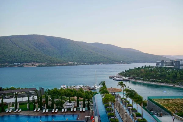 Bodrum, Türkiye - Ağustos 2020: Hotel Beach Lujo. Cennet 'te tatil. Güzel tropikal plaj afişi. Beyaz kum turizmi geniş panorama arka plan konsepti. İnanılmaz sahil manzaraları, yatlar.