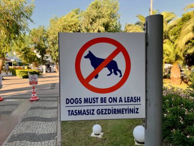 Yol kenarında bir işaret: Köpekler tasmalı olmalı.