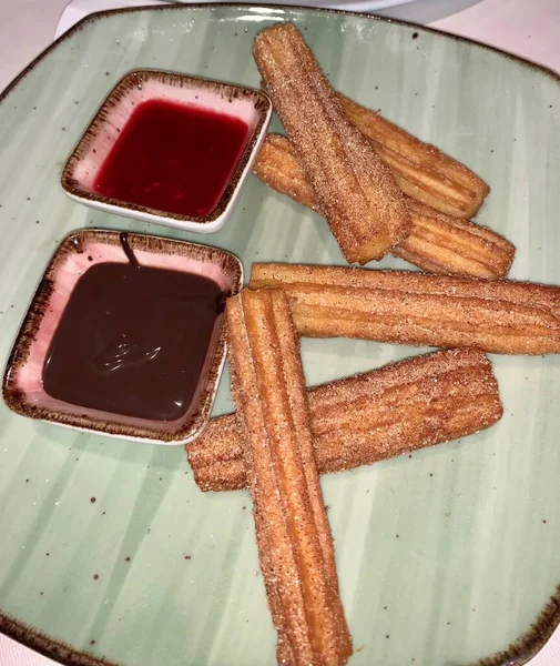 Delicious Hourglass cookies on a green plate with raspberry and maple syrup — Stock Photo, Image