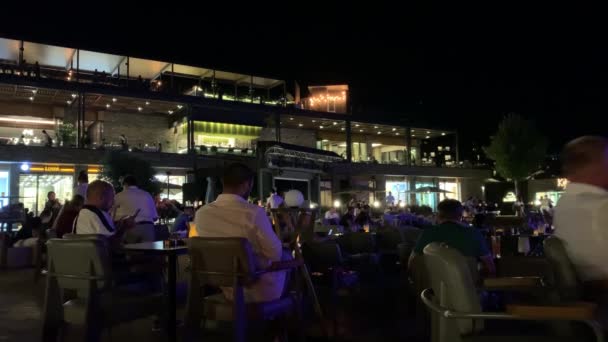 Bodrum, Turchia - Agosto, 2020: La gente si gode il prossimo concerto sul palco estivo con camerieri che corrono tra i tavoli. Video 4K — Video Stock