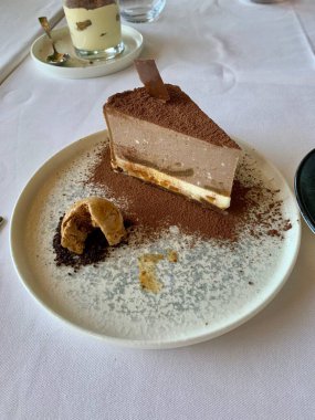 Bir tabak çikolatalı kek, bir fincan kahvenin yanında.