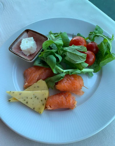 A white plate of healthy food on a table, Healthy food clean eating selection: Avocado Arugula Cherry Salmon Cheese, Vegan dinner eating on the Atlantic — Stock Photo, Image