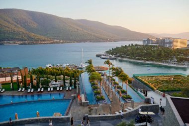 4K Panoramik Körfez manzaralı zümrüt Ege Denizi, yatlar, beyaz kum, yeşil dağlar. Lüks gebelik