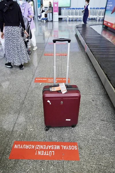 Bodrum, Törökország - 2020 augusztus: Piros bőrönd a poggyászkihordó vonal közelében a repülőtéren, elveszett poggyász. Bőrönd a repülőtér indulási várótermében, nyaralás koncepció, utazók bőröndjei a repülőtéri terminálban várakozás — Stock Fotó