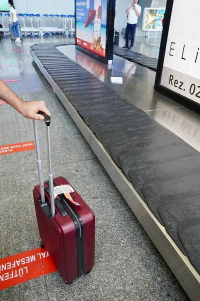 Bodrum, Τουρκία - Αύγουστος 2020: Κόκκινη βαλίτσα κοντά στη γραμμή παραλαβής αποσκευών στο αεροδρόμιο, Βαλίτσες στο σαλόνι αναχώρησης του αεροδρομίου, έννοια διακοπών, ταξιδιωτικές βαλίτσες στον τερματικό σταθμό του αεροδρομίου, άδεια — Φωτογραφία Αρχείου