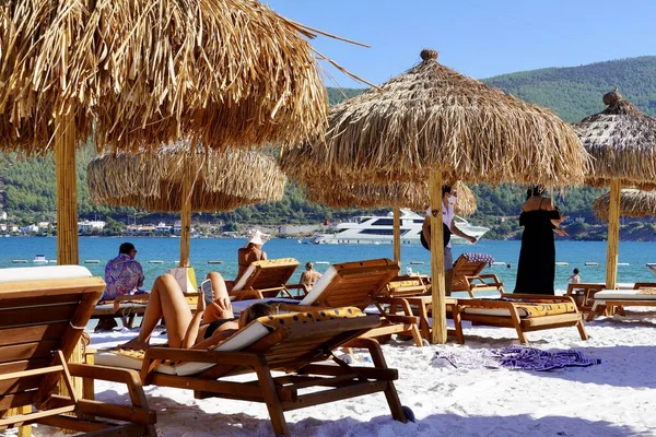 Бодрум, Туреччина - серпень 2020: сніжно-білий пляж готелю Lux з смарагдовою водою Егейського моря. Яхтс.Люди купаються на пляжі. На пляжі лежатимуть сонячні ліжка. Зменшення концепції вільного доступу до потомства — стокове фото
