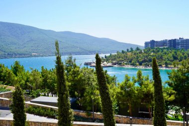 Ege Denizi 'nin zümrüt körfezinde yeşil tepeler, okaliptüsler ve kar beyazı yatlarla güzel panoramik manzaralar. Lüks turizm konseptini gevşetiyor
