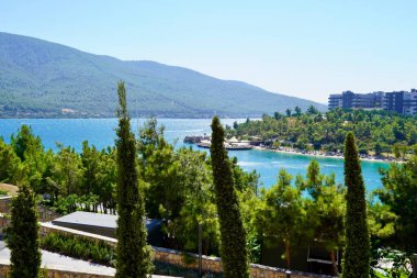 Ege Denizi 'nin zümrüt körfezinde yeşil tepeler, okaliptüsler ve kar beyazı yatlarla güzel panoramik manzaralar. Lüks turizm konseptini gevşetiyor