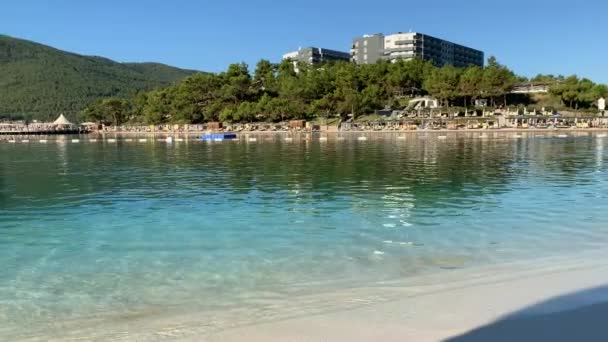 4K Gyönyörű panoráma paradicsom kilátás nyílik a szálloda strandjára Lujo fehér homokkal, jachtok, házak a víz a lagúnában smaragd víz az Égei-tenger, Luxus turisztikai koncepció — Stock videók