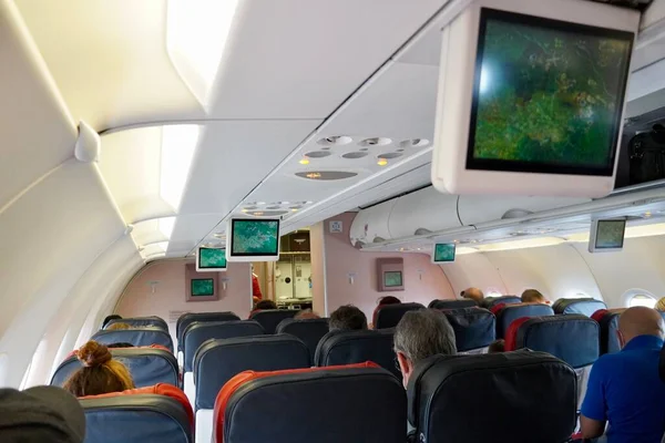Люди в салоне пассажирского самолета перед полетом — стоковое фото