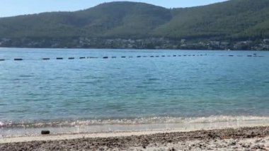 4K Güzel panoramik cennet manzaralı plaj beyaz kumlu, yatlı, göl kıyısında Ege Denizi 'nin zümrüt suyuyla kaplı evler, lüks turizm kavramı.