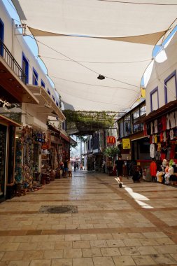 Bodrum, Türkiye - Ağustos 2020: Bodrum 'daki Marina Körfezi pazarındaki turistler dar sokaklarda hediyelik eşya görüyorlar. Turistler için dükkanlar. Gezginler için otantik mallar. Bodrum 'da hediyelik eşya. Doğu aromalı ve...
