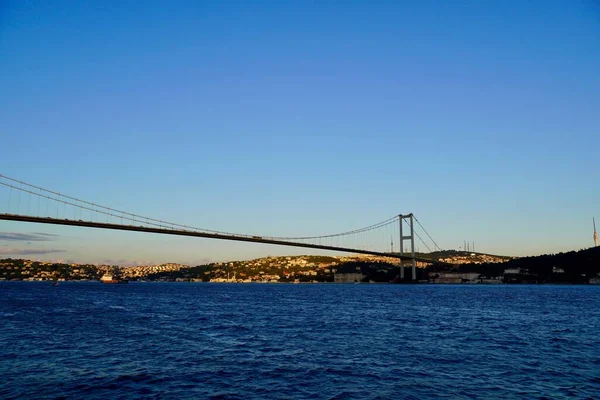 Toeristische boten varen onder de brug door in Istanbul. Reizen op de Bosporus. Panoramisch uitzicht, Uitzicht op de eerste Bosporusbrug. — Stockfoto