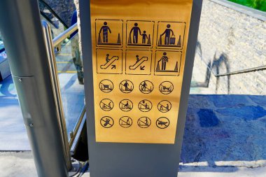 Yürüyen merdivendeki insanların davranışlarını gösteren kılavuz.