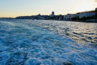 Boğaz 'dan geçen turist yolcu gemilerinin köpüren mavi dalgaları. İstanbul, İstanbul, Türkiye 'deki İstanbul' da bir yolcu feribotunun arkasında köpüren su izi.