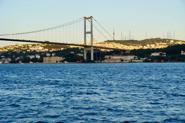 Turistahajók hajóznak a híd alatt Isztambulban. A Boszporuszon utazom. Panoráma kilátás, kilátás az első Bosphorus-híd sailling Bosporus. — Stock Fotó