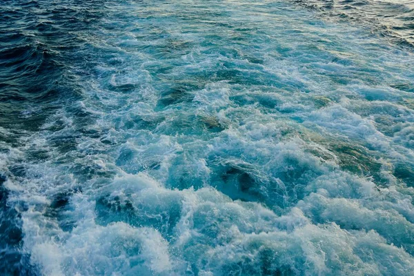 Borbulhando ondas azuis de vestígios de navios de cruzeiro turístico passando no Bósforo. Trilha aquática espumando atrás de um barco de balsa de passageiros em Bosphorus, Istambul, Turquia. — Fotografia de Stock