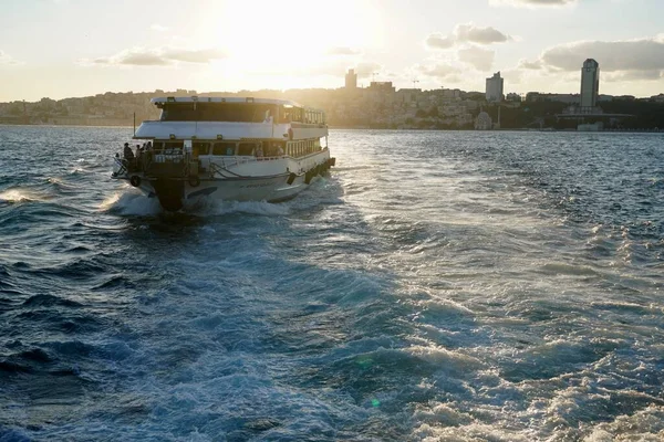 Blubbernd blaue Wellen von Spuren touristischer Kreuzfahrtschiffe, die am Bosporus vorbeifahren. Wasserspur schäumt hinter einer Passagierfähre im Bosporus, Istanbul, Türkei. — Stockfoto