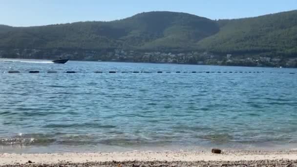 位于土耳其卢霍豪华饭店的一座白色海滩上，4K翡翠湖俯瞰着长青的山丘，上面有雪白的生态游艇、日光浴和竹伞 — 图库视频影像
