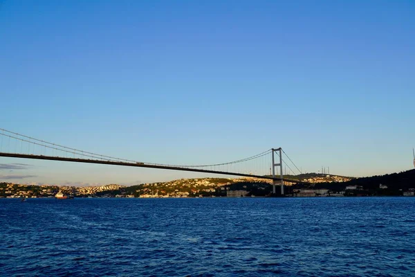 Toeristische boten varen onder de brug door in Istanbul. Reizen op de Bosporus. Panoramisch uitzicht, Uitzicht op de eerste Bosporusbrug. — Stockfoto